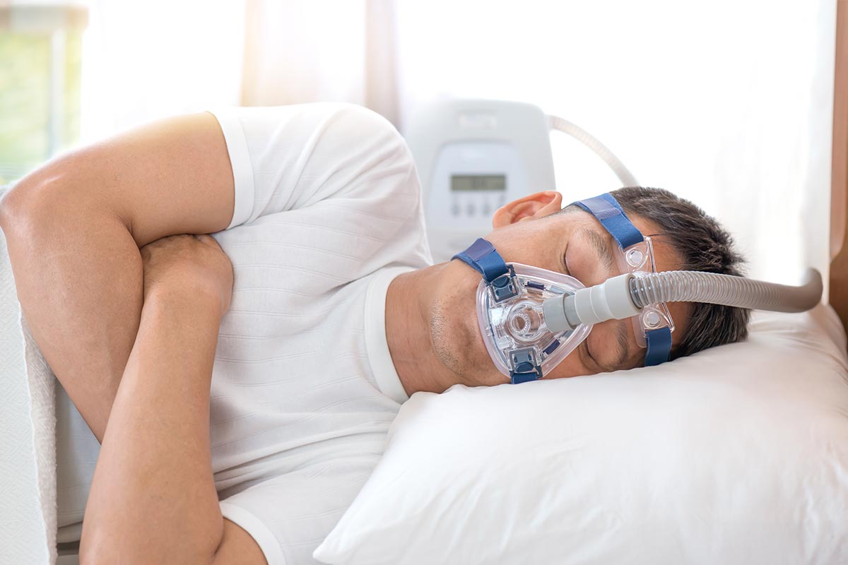 hombre tumbado con tratamiento de apnea del sueño